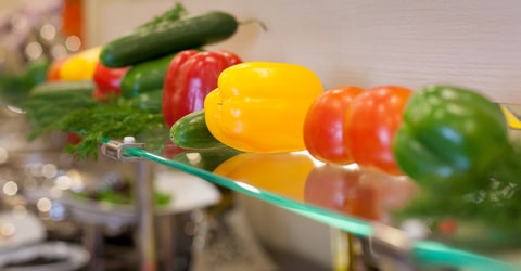 Gemüse liegt auf einer Glastheke